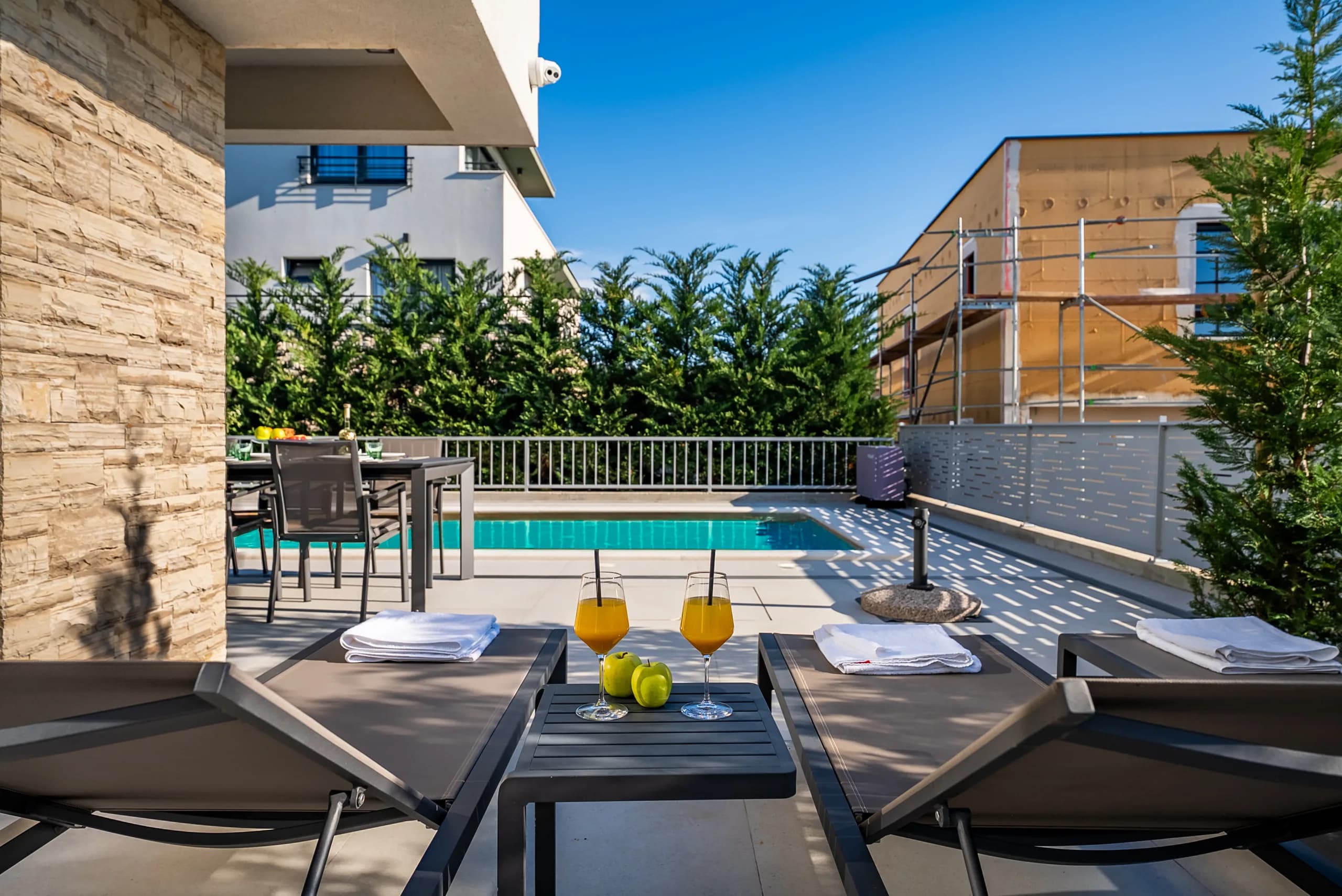 Sun loungers with drinks by the pool at Villa Tamaris